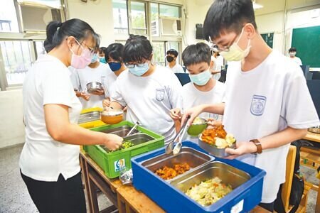台北市懷生國中老師1日中午在教室內分配營養午餐給學生。(張鎧乙攝)