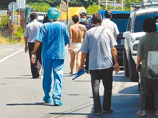 台東38歲林姓男子(中,著紙尿布者)5日遭家中魚竿貫穿頭部,初步治療後,手術前他竟穿著尿布逃離醫院近1小時,最後由醫護、警察、家屬苦勸才返院就醫。(台東馬偕醫院提供/蔡旻妤台東傳真)
