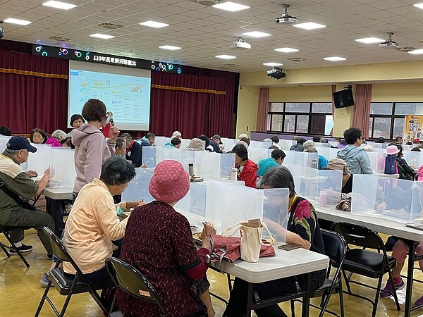 建安里里民「長青樂活遊臺北」出遊中餐用餐時使用隔板防疫。(圖/擷取自建安里幸福有里粉絲專頁)