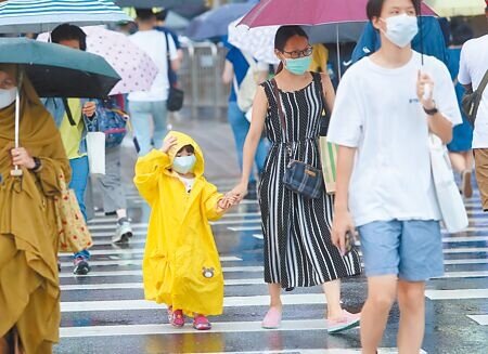 梅花颱風持續接近台灣東北部,中央氣象局11日發布海上颱風警報,北部下起豪雨,民眾紛紛帶著雨具外出。(鄭任南攝)