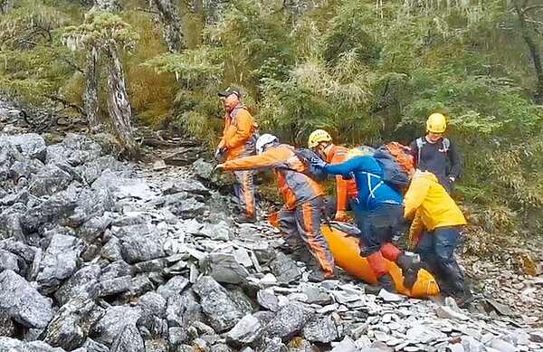 搜救人員將法官陳伯均遺體妥善打包合力搬運，因現場岩石陡峭，加上落差大，天然地形舉步維艱。（台中市消防局提供／陳世宗台中傳真）