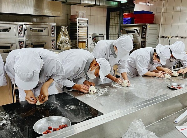 能仁家商餐飲科學生為饅頭鑲上紅棗。圖/新北市文化局提供