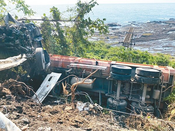 宜蘭頭城台二線有砂石車衝出路邊護欄,卡在邊坡,底下十公尺就是鐵軌,台鐵第一時間卻僅封鎖單線。圖/讀者提供