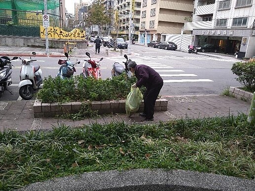 環保志工們會連花壇草堆的垃圾一併清除。圖／取自台北市鄰里服務網
