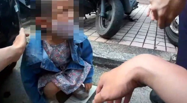 高市2歲女童獨自蹲在鳳山區的路邊嚎啕大哭,警方趨前關切。記者石秀華/翻攝