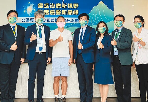 北醫質子中心正式投入臨床治療,匯集臺北醫學大學醫療體系的跨體系量能,試營運迄今完成11位病人的治療。圖為質子中心團隊與王先生。圖/北醫附醫提供