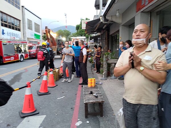 台東6.8強震導致花蓮玉里鎮中山路二段一處大樓倒塌,大樓壓到隔壁超商,傳出有五名顧客受困在裡面,一旁的民眾幫忙合十祈禱。記者季相儒/攝影