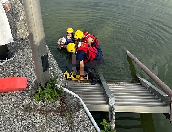 高雄蓮池潭今天上午又發現浮屍,消防員將漂浮在物產館後方碼頭的男性死者打撈上岸,隨後確認身分是66歲劉姓男子。圖/讀者提供