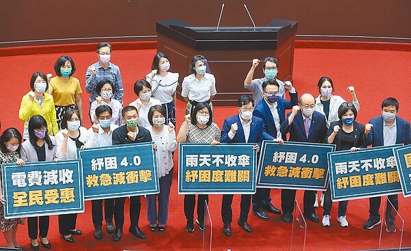 行政院8400億防疫紓困特別預算中,紓困占56.5%,振興23.98%,防疫僅19.52%。國民黨團質疑,大部分都用在發錢,資源配置有問題。圖為去年立法院三讀通過「紓困4.0」追加預算案,民進黨籍立委在議場合影。(台北市攝影記者聯誼會提供)