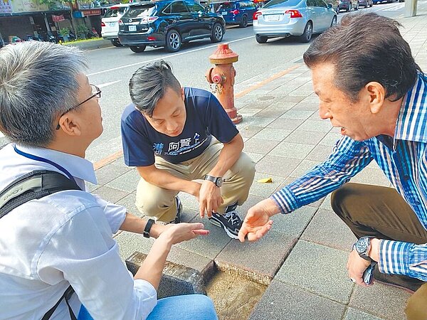 北市議員李明賢（左二）發現，許多舊的人行道鋪面已破損，並形成高低落差造成行人通行危險，又容易積水，除整體不美觀也影響通行。（李明賢辦公室提供／游念育台北傳真）