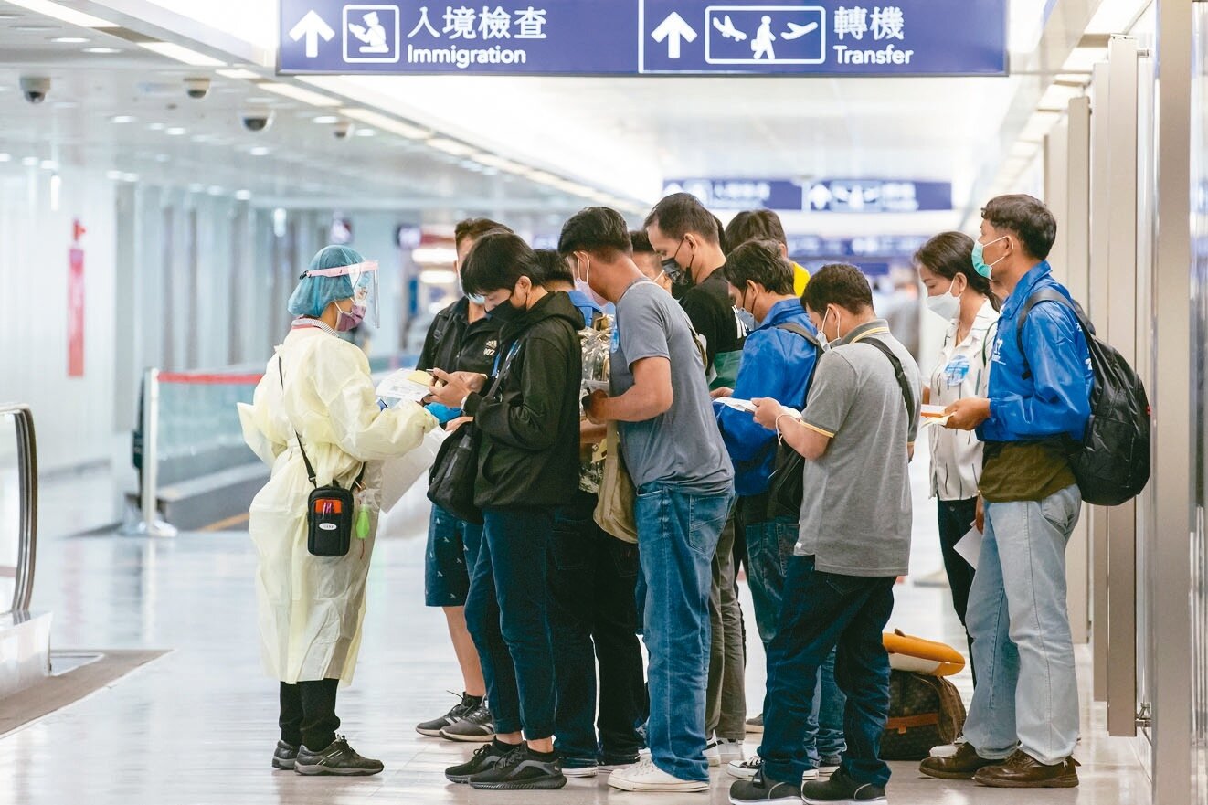 勞動部昨宣布,十月十三日起,同步實施「○加七」移工入境防疫措施,圖為桃園機場外籍移工在入境後於登機門外確認相關資料。記者季相儒/攝影