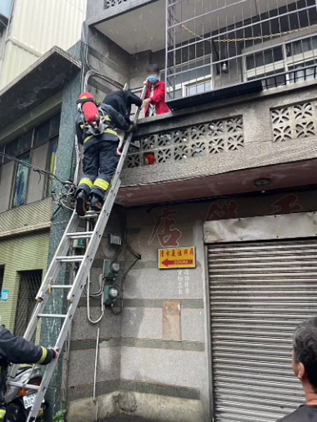 淡水區重建街1幢透天厝下午發生火警,消防隊從2樓陽台救下2名老婦人。記者林昭彰/翻攝