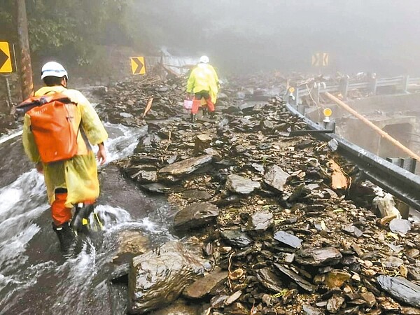 宜蘭消防勇士背著油料物資及藥品徒步七小時,走過充滿碎石、斷樹及泥流的艱險路段,終於送達20名患者的救命藥。圖/消防局提供