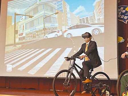 
桃園市教育局長林明裕實際體驗自行車危險情境VR體驗系統，做最壞示範，以提醒學生「VR遊戲可以重新來過，但現實生活不行！」（陳夢茹攝）
