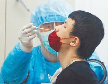 醫師建議民眾,現階段如須急赴日本,可以先選擇自費PCR。圖為民眾採檢的畫面。(本報資料照片)