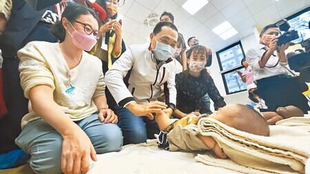 新北市長侯友宜出席公托聯合開幕儀式,也體驗替小嬰兒按摩。(呂健豪攝)