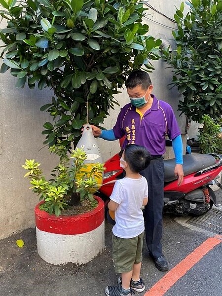 里長與小朋友介紹街道的裝置藝術。圖／廖詠琦攝

