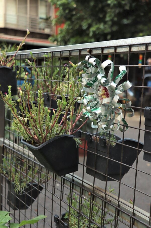 網架上的花朵裝飾，是由社區長輩利用回收物品所創作。圖／林昕璿攝