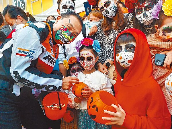 新北萬聖節活動29日在板橋府中商圈盛大舉行,有全家人一起扮成「可可夜總會」動畫電影裡的角色,新北市長侯友宜也打扮成鬼王賽車手。(新北市經發局提供)