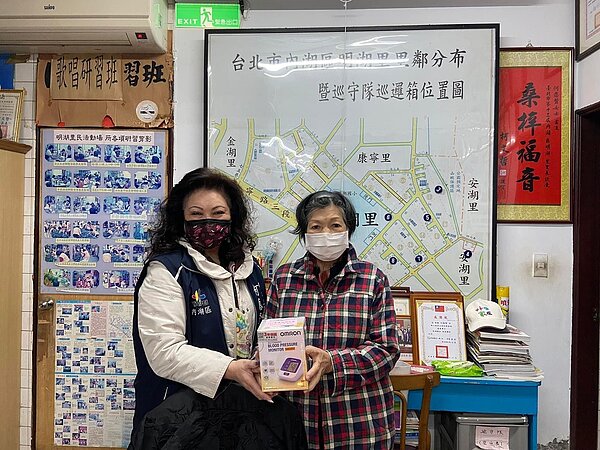 何應賢（左一）關懷長者，致贈血壓計給里民使用。圖／明湖里辦公處粉專提供
