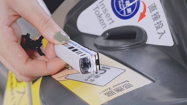 旅客使用「3D造型悠遊卡」進出車站,透過感應閘門即會響起「嗶嗶嗶」列車離站警示音,車頭燈光亦隨之閃爍。圖/台北捷運公司提供