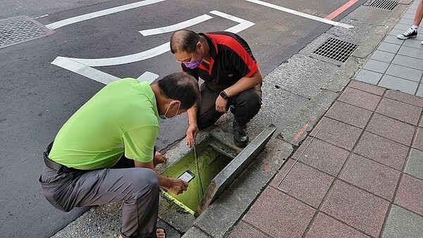 吳永華里長協助學生撿水溝內耳機。圖／取自「吳永華」臉書