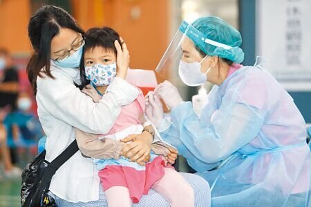 許多家長反映,滿5歲的幼童不好預約BNT疫苗,桃園市政府宣布5月31日起兩天在4所學校增設5至6歲兒童的疫苗快打站,圖為桃園區青溪國小快打站施打BNT疫苗,一位小女生依靠在母親身邊完成疫苗施打。(陳怡誠攝)