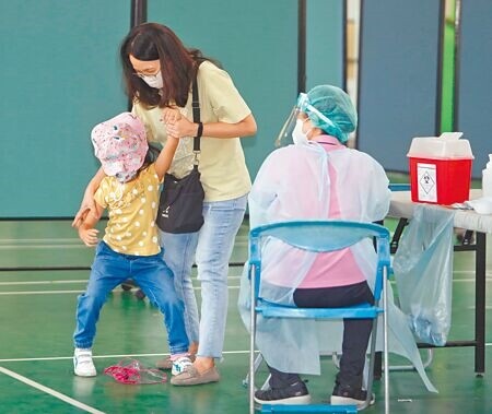 許多家長反映，滿5歲的幼童不好預約BNT疫苗，桃園市政府宣布5月31日起2天在4所學校增設5至6歲兒童的疫苗快打站，31日桃園區青溪國小快打站施打BNT疫苗，一位小朋友臨陣不願意接種疫苗，讓陪同的母親趨前勸拉至注射區施打疫苗。(陳怡誠攝)