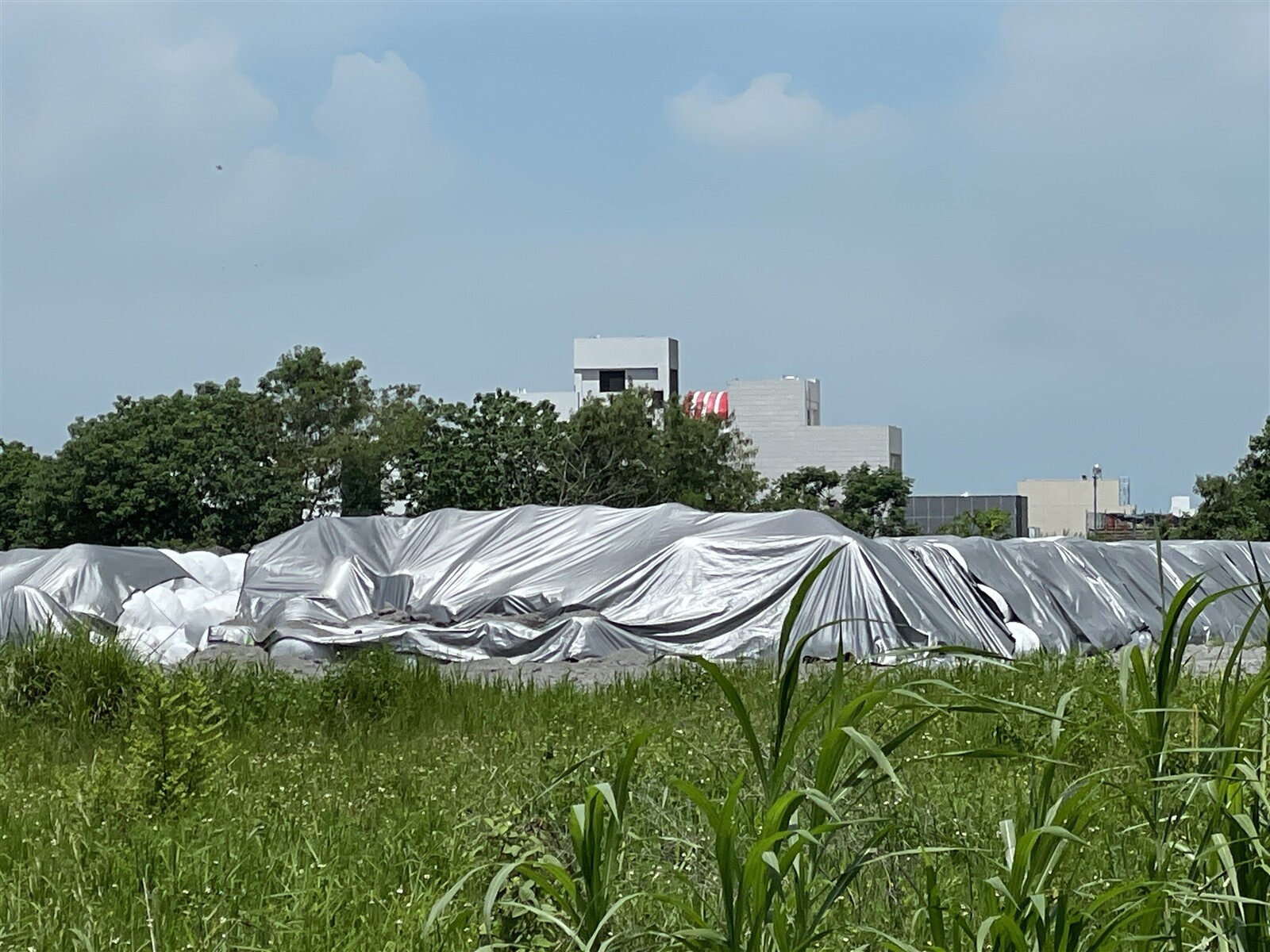 嘉義市焚化爐5月擴大歲修，累積4000公噸暫堆在湖子內環保用地，市府用帆布蓋住。記者林伯驊／攝影 