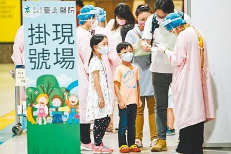 中央1日起在六都設置大型兒童疫苗接種站,一早陸續有家長帶著孩子前往新北市板橋車站掛號打疫苗。(郭吉銓攝)