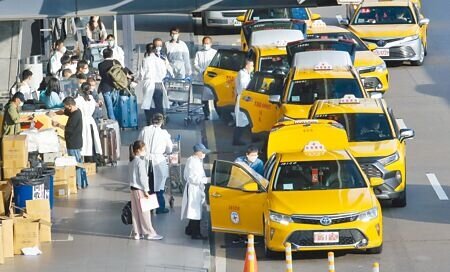 中央流行疫情指揮中心3日表示,未來邊境鬆綁政策將包括開放親友接機或自駕,不再強制要求搭乘防疫計程車,相關配套尚在研擬中。圖為桃機旅客搭防疫計程車的畫面。(范揚光攝)