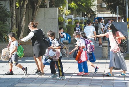 
台北市遠距教學至6月3日，國高中、小學及幼兒園學童3日前疫苗接種完畢，6日正式恢復實體上課，圖為家長送小孩到校門口。（陳俊吉攝）
