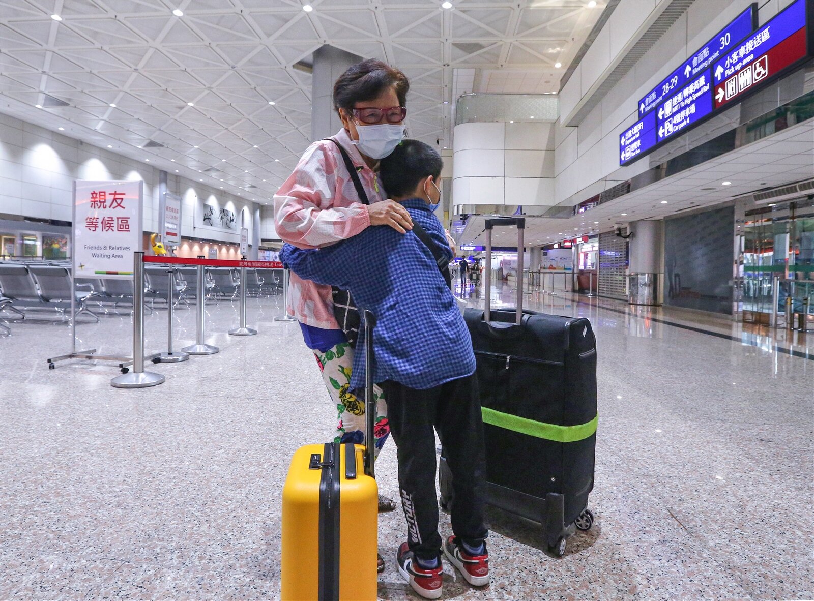 指揮中心昨開放親友接機，沈家祖孫二人分隔兩年多，沈小弟步出海關，看到阿嬤便開心上前擁抱。記者黃仲明／攝影 