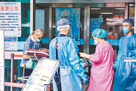 
新冠肺炎疫情延燒，國內21日新增56339例本土個案，重症個案中115人死亡。圖為救護車將病患送至新店耕莘醫院急診室，醫護人員詢問病患狀況。（羅永銘攝）
