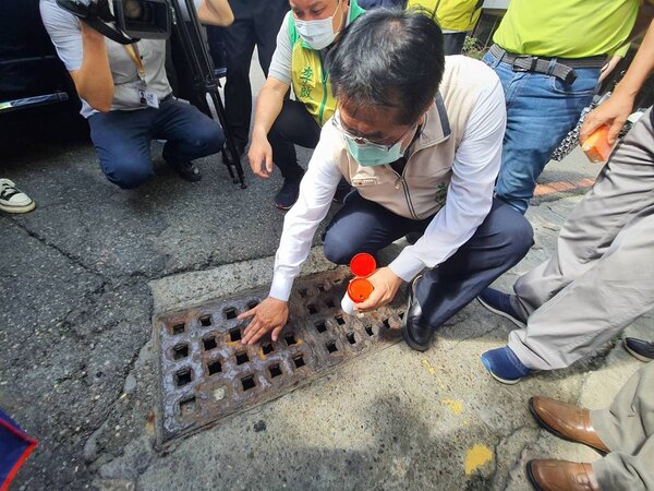 台南市環保局25日在安平區舉辦環境清孑總動員，市長黃偉哲在水溝預防性投藥消滅蚊蟲。圖／台南市環保局提供