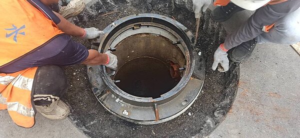 工作人員正在更換耐揚壓框蓋，避免人孔蓋因為壓力關係彈出傷及旁人。圖／北市衛工處提供