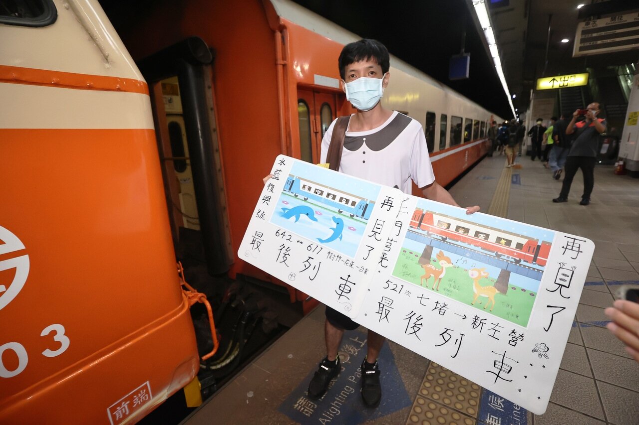 鐵道迷手持自製看板,和最後一班摺疊門莒光號留下合影。記者劉學聖/攝影