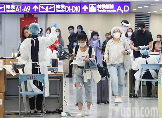 入境旅客繳交檢疫資料後,領取居檢期間使用的快篩試劑。圖/記者黃仲明/攝影