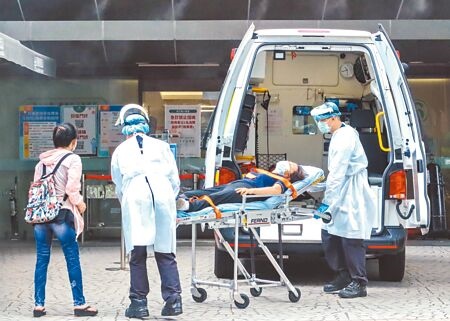 國內昨日本土確診人數新增42112例，死亡個案新增85例，圖為救護車推出一位病患送至急門診處。（粘耿豪攝）