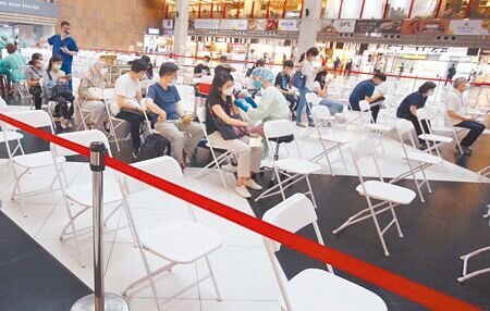 疫情指揮中心昨宣布，7月1日起擴大第4劑接種對象，包括機場港埠、居家檢疫、航空機組員及機構與社福照護系統相關工作人員皆可。圖為在台北車站的接種站內，民眾排隊依序施打疫苗。（范揚光攝）