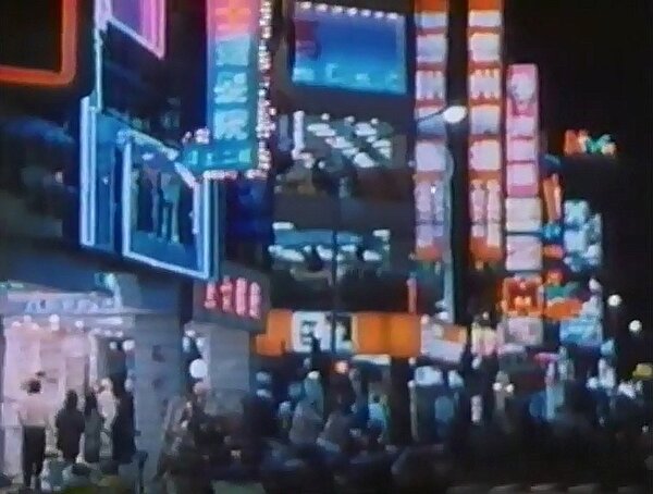 這是西門町的電影街（武昌街二段底），可以看到當時在昆明街與武昌街口有小騎士德州炸雞（來來百貨斜對面），它的隔壁則是臺灣第一家肯德基餐廳（1985年4月16日開幕，就在樂聲戲院的正對面）。
