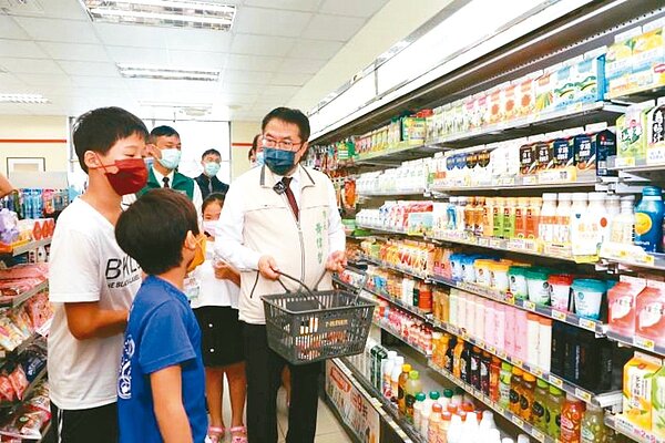 台南市愛心餐食補給站計畫1日開跑,市長黃偉哲(右)帶著孩子持愛心餐券到超商領取食物,並宣導多挑選有營養可幫助成長的食物。圖/台南市府提供