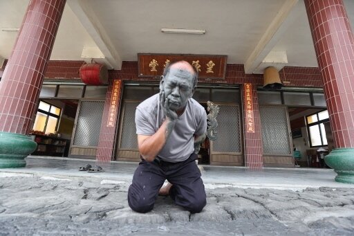 屏東萬丹泥火山6月底爆漿，有民眾跪在皇源聖殿外，取泥漿敷臉，專家說不宜。記者劉學聖／攝影 