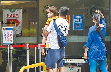 國內疫情有趨緩跡象,中央流行疫情指揮中心發言人莊人祥說,本土疫情要降到單日1萬例以下「恐怕沒那麼快」,目前看來可能要等到7月底。3日醫院的防疫急門診外,家長抱著小孩前來看診。(陳俊吉攝)
