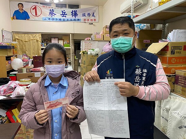 小朋友到里長辦公處領取期末考100分的獎學金。圖/萬華福音里粉絲團提供