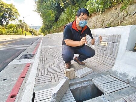 基隆市中正公園大佛禪院前人行步道日前完工，但3公分厚的水泥水溝蓋竟輕易被民眾一腳踩破，遭質疑是豆腐渣工程。（陳彩玲攝）