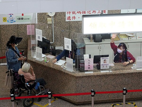 退休軍公教月退金將自今年7月起調增2%,合計受惠退休軍公教總數約53萬餘人。圖為領事事務局的職員正在幫忙民眾洽公。 聯合報系資料照/記者邱德祥攝影