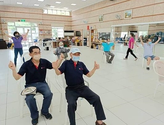 志工賣力在關懷中心服務，大家一條心。圖／里辦提供


