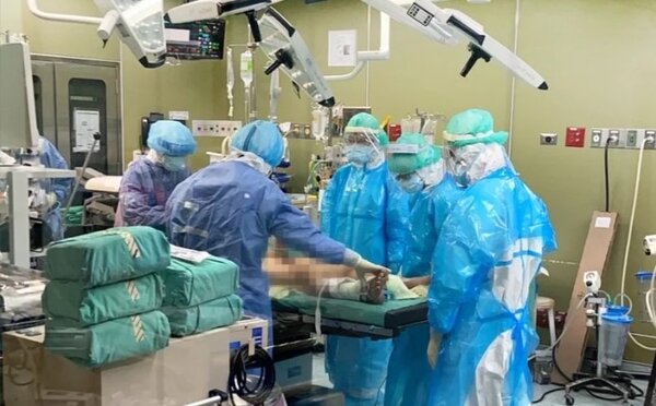 全程穿著乙級防護隔離裝備的馬偕醫院手術團隊，為病人做手術。圖／馬偕醫院提供