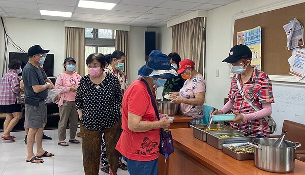 里民有秩序地拿著自備的便當盒排隊盛取餐點。圖／蔡愷恆／攝